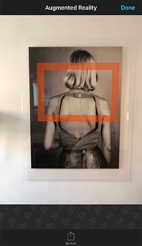 Augmented reality view showing an orange rectangle framing a photograph on a wall, previewing the camera's field of view