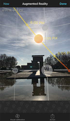 Augmented reality view showing the Sun's path overlaid on a real photo of a monument, with time markers along the path